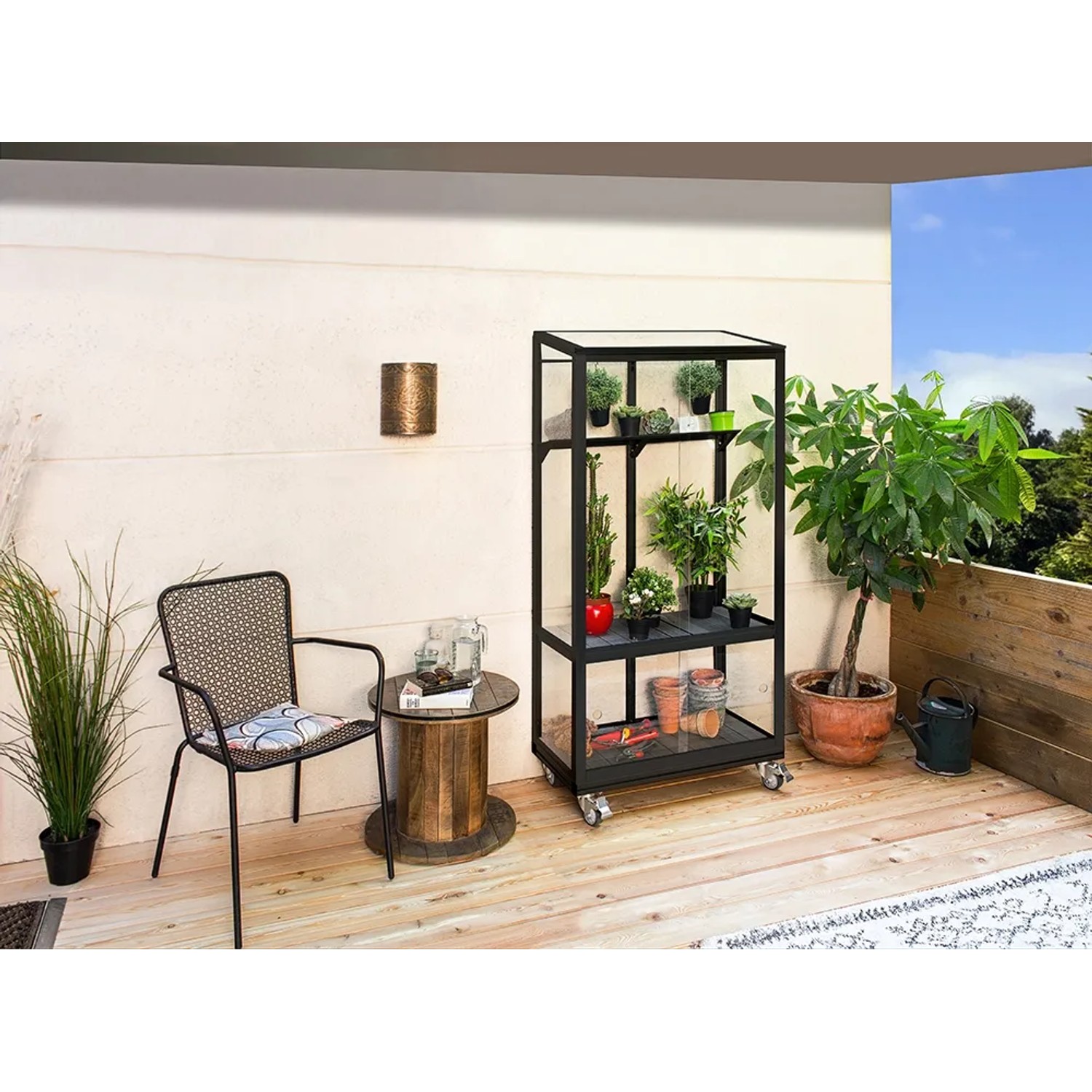 Vitavia Polis Balkongewächshaus schwarz mit Rollen und Pflanzen auf einem Balkon.
