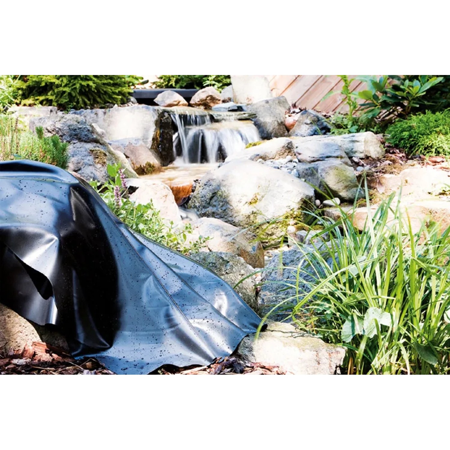 Schwarze Heissner PVC Teichfolie (6x6m) am Teich mit Wasserfall im Garten.