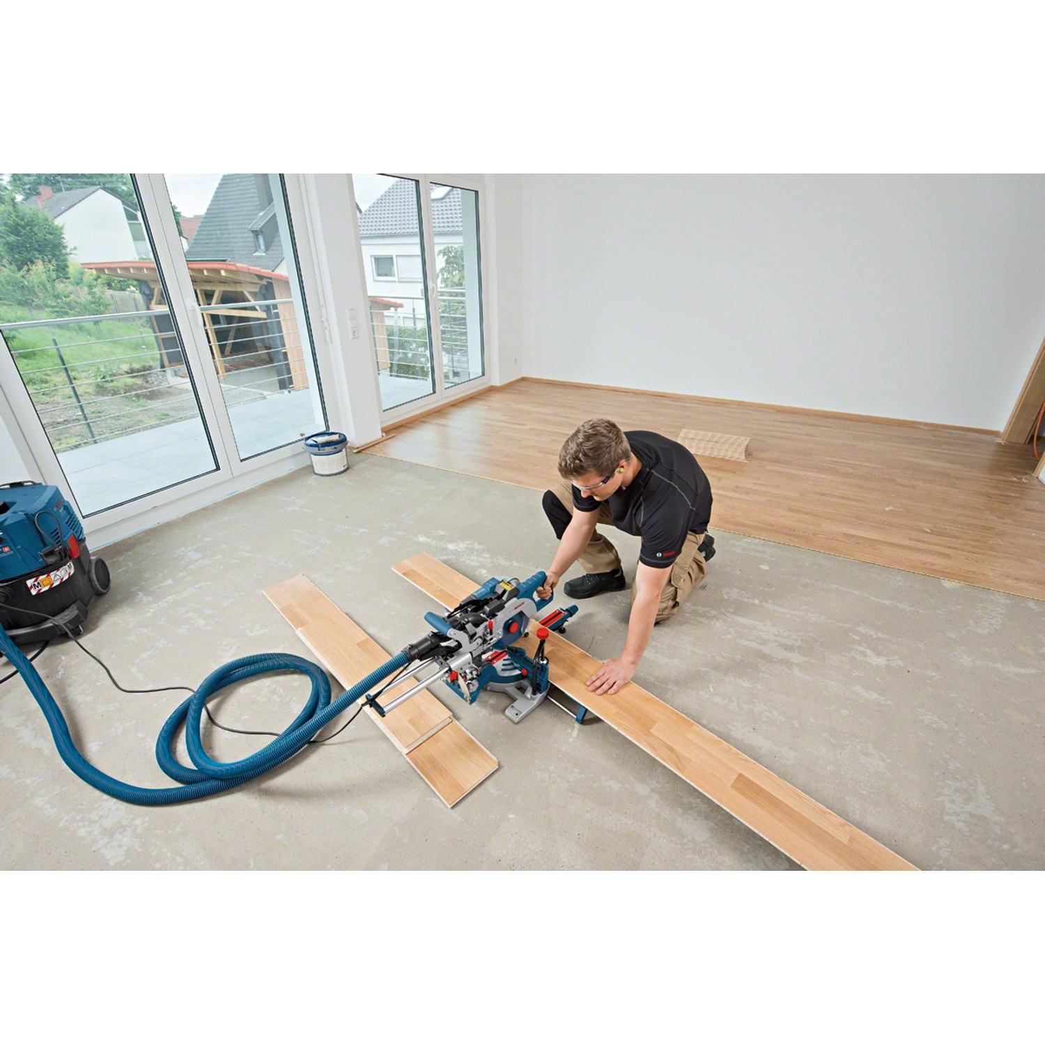 Bosch Professional GCM 8 SDE Paneelsäge beim Zuschnitt von Holzdielen in einem Raum.