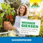 Frau hält Topf mit Pflanze und Neudorff Wasserspeicher Schild. Bodenverbesserer für weniger Gießen.