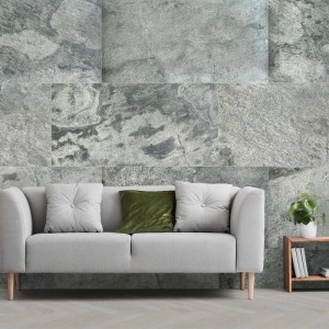 Echtstein-Paneel Glimmer Schiefer 122x61cm an einer Wand hinter einem Sofa. Graue Naturstein-Verblender mit Struktur.