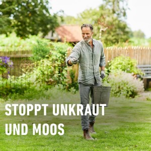 Mann düngt Rasen mit Bio-Rasendünger gegen Unkraut und Moos.