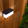 Schwarze Lutec LED Solar-Wandleuchte Fran an Holzwand. Moderne, eckige Außenleuchte mit Bewegungsmelder.