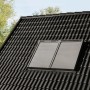 Alufarbener Rolladen Solarantrieb Modular CK02 auf einem Dachfenster montiert.