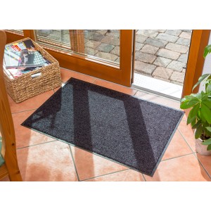Schwarze Astra Sauberlaufmatte Proper Tex Uni, 90x250 cm, vor einer Tür.