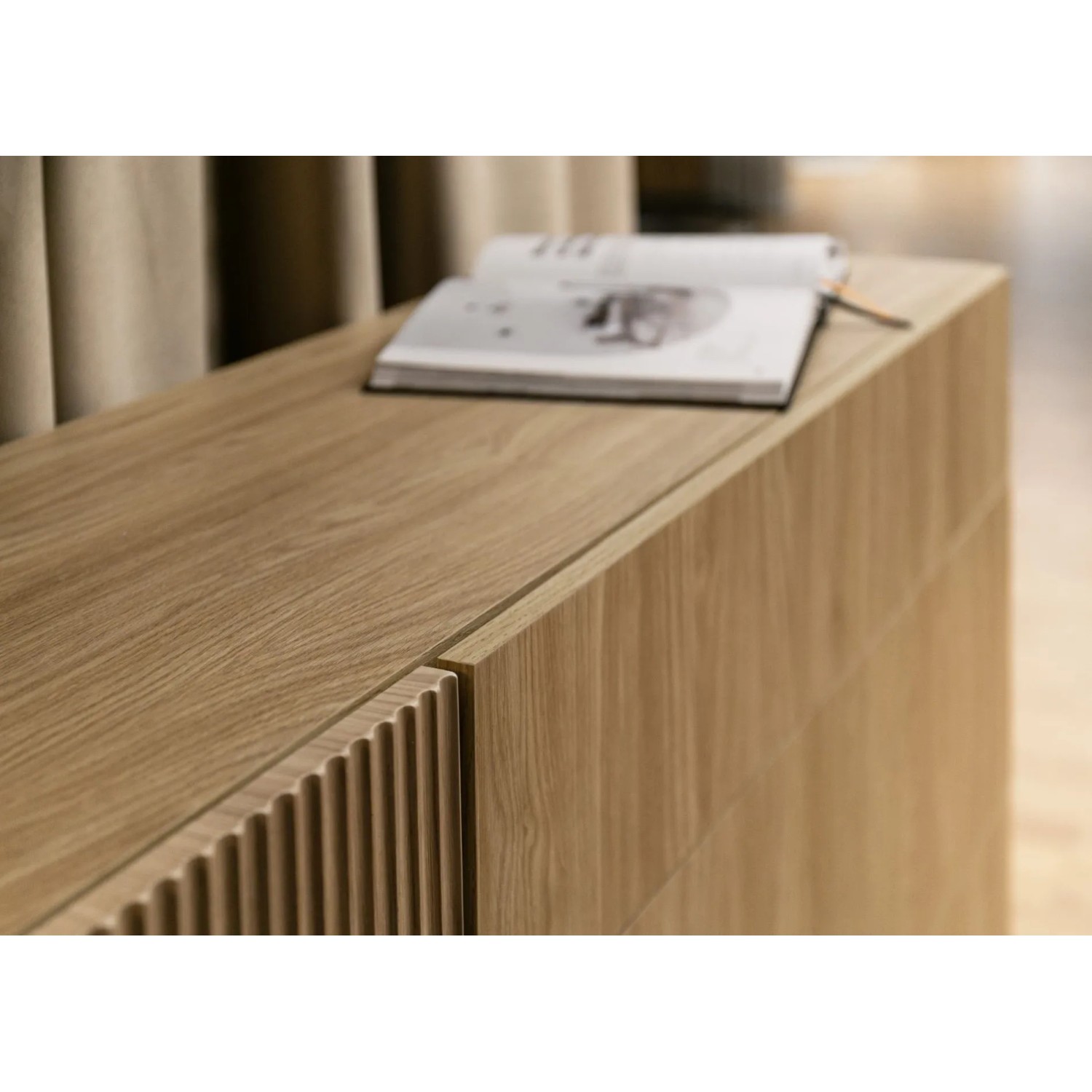 Selsey Nolie Sideboard aus geölter Eiche. Detail der geriffelten und glatten Fronten, Buch auf der Ablage.