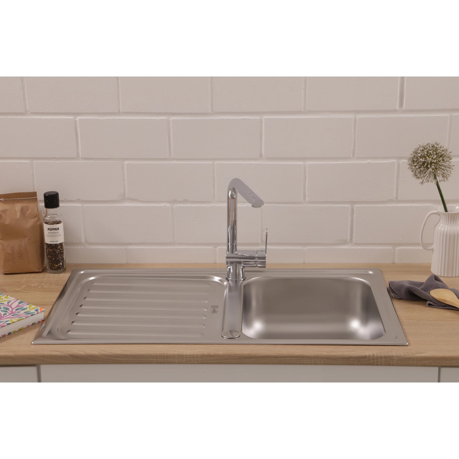 Respekta Edelstahlspüle Riverside, 86x50 cm, mit Abtropffläche und Armatur auf einer Küchentheke.