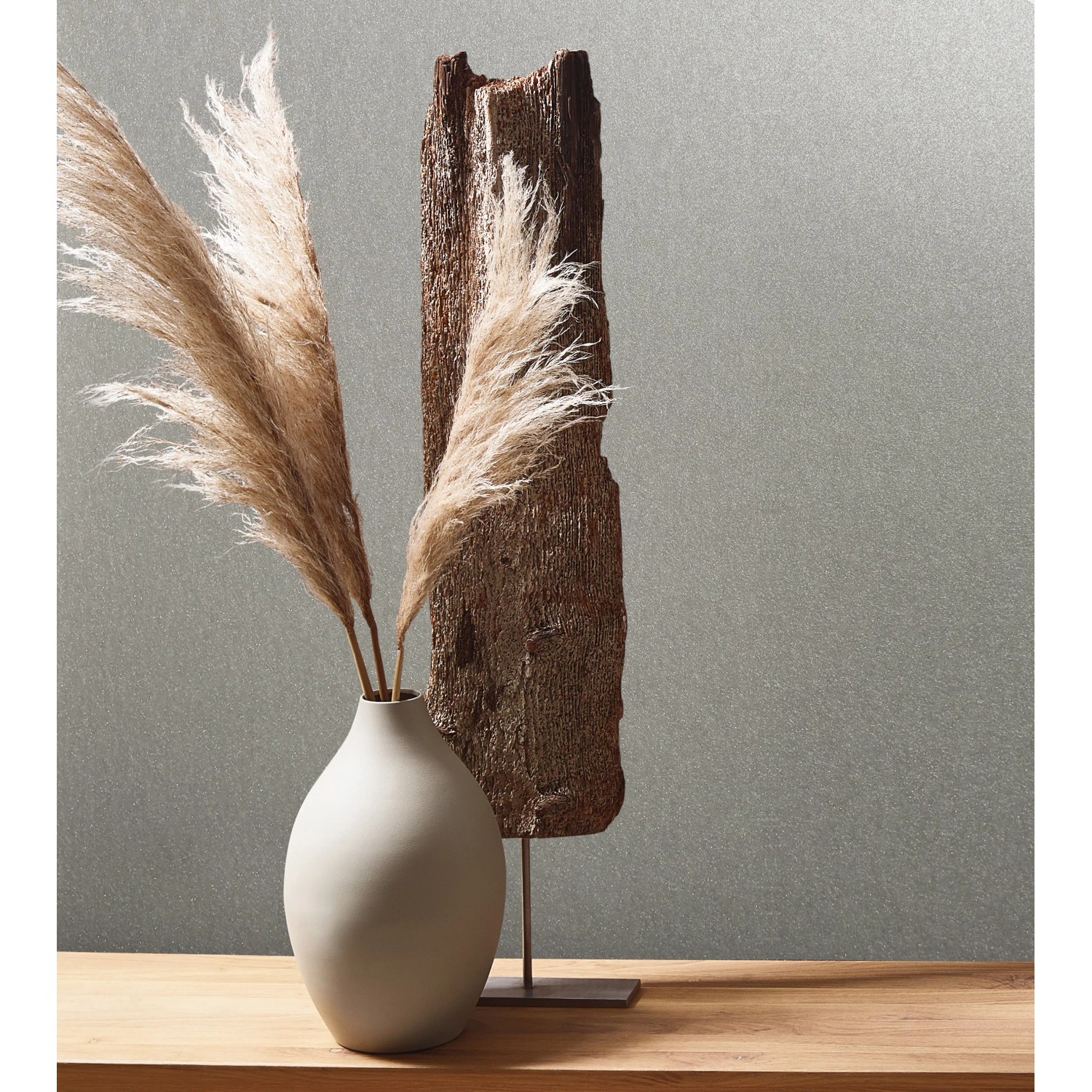 Graue Marburg Tapete in Metalloptik mit Schimmer, kombiniert mit Deko-Elementen auf einem Holztisch.