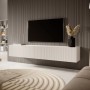 Modernes weißes Selsey TV-Hängeboard Veldio mit geriffelter Lamellenfront, 175 cm, schwebend unter einem TV im Wohnzimmer.