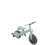 Pistazienfarbenes Globber Explorer Trike 4in1 Kinderdreirad mit roten Pedalen und verstellbarem Sitz.