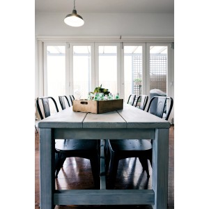 Holztisch mit Rust-Oleum Weathered Wood Ash Grau Effektfarbe, umgeben von Stühlen.