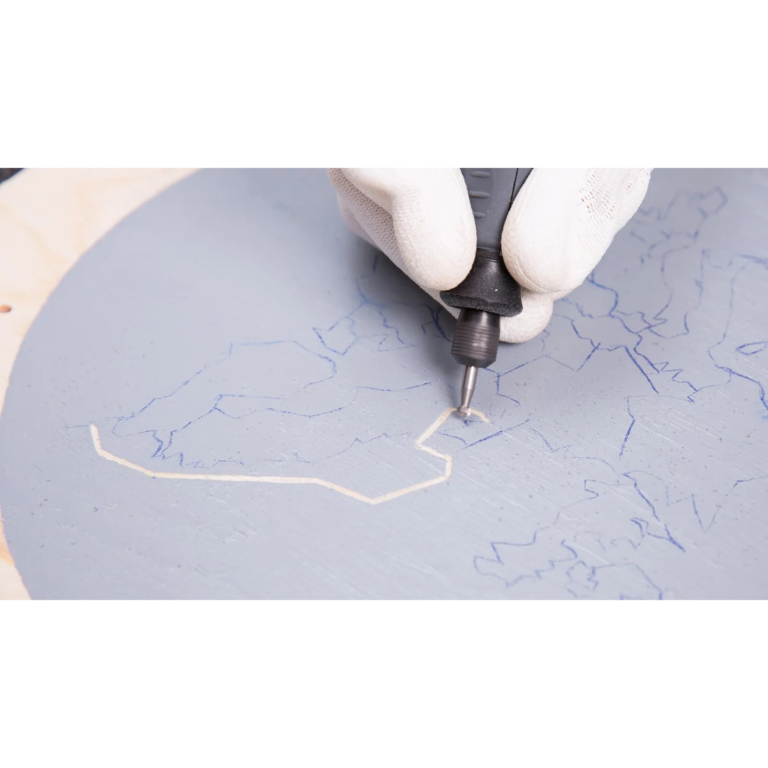 Dremel Holzbearbeitungs-Set in Nutzung: Gravur einer Weltkarte auf Holz.