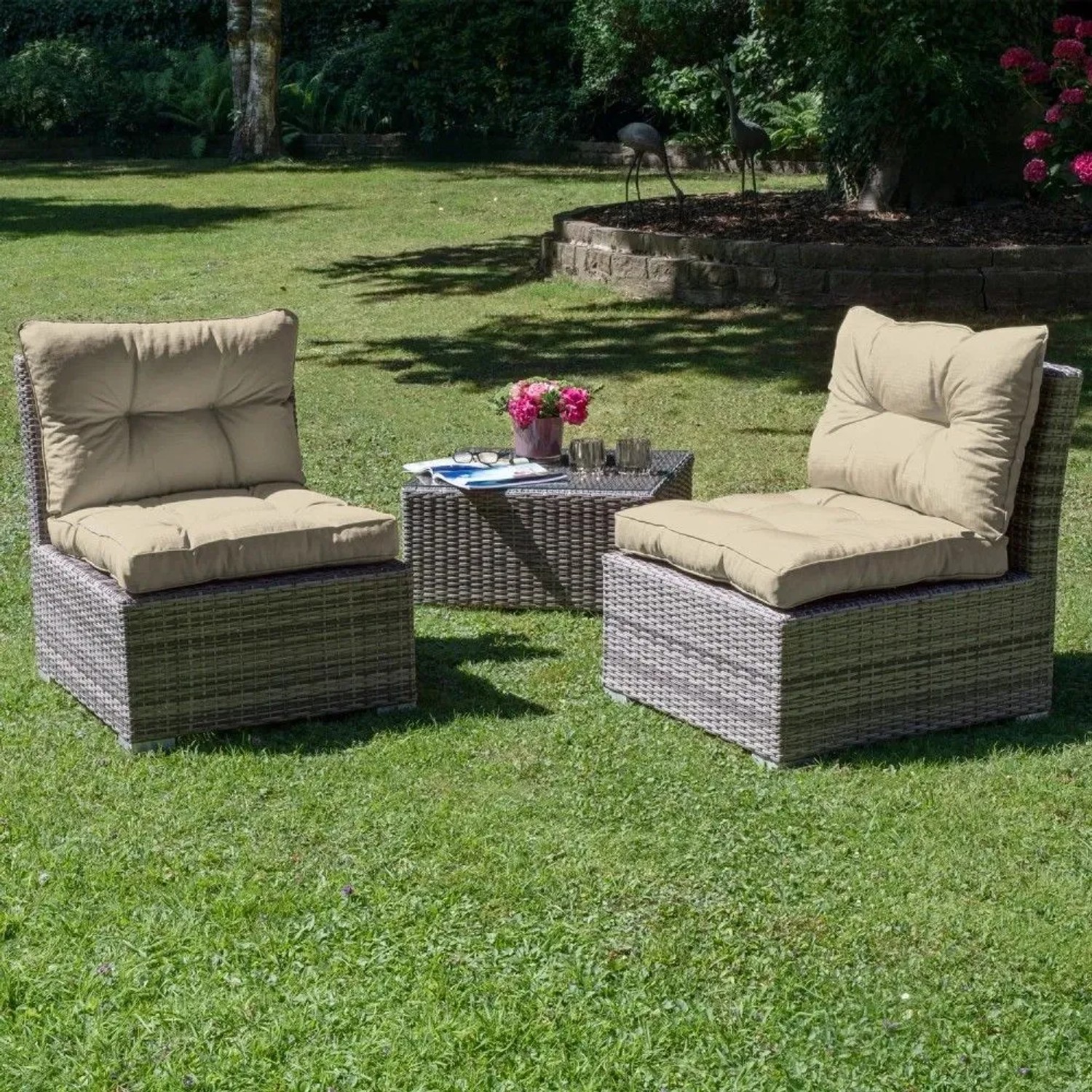 Beige Lounge-Rückenkissen auf grauen Rattan-Gartenstühlen im Grünen. Mit Paspelierung, für Gartenmöbel.