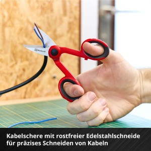 Einhell Werkzeugkoffer: Hand hält rote Kabelschere beim Schneiden eines Kabels.