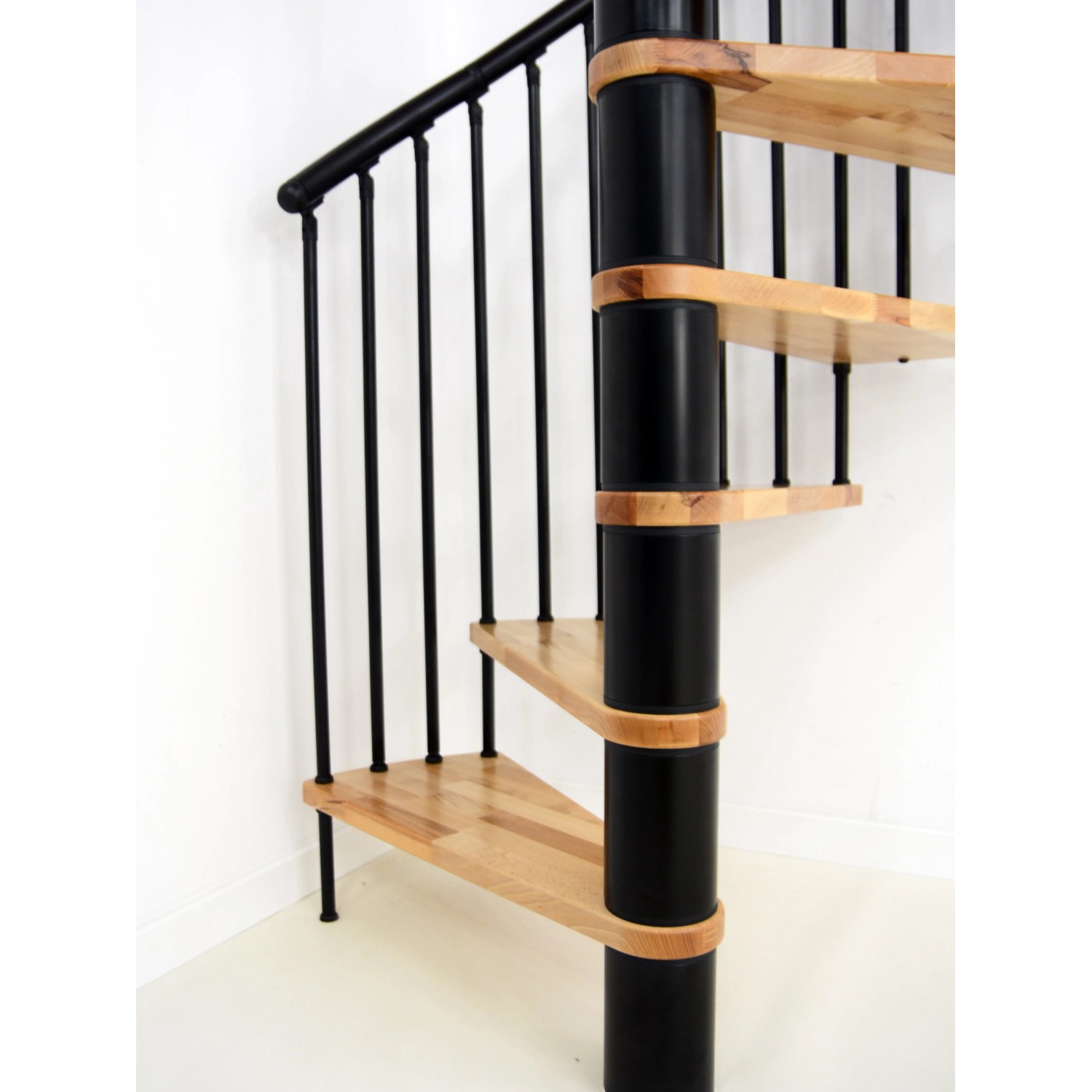 Minka Spindeltreppe Spiral Effect, Buche schwarz, Ø 120cm. Innentreppe mit Holzstufen und schwarzem Geländer.