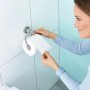 Frau entnimmt Toilettenpapier von tesa LOXX Toilettenrollenhalter, hochglanzverchromt.