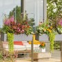 Lechuza Balconera Stone 80, steingrauer Blumenkasten mit üppiger Bepflanzung auf einem Balkon.