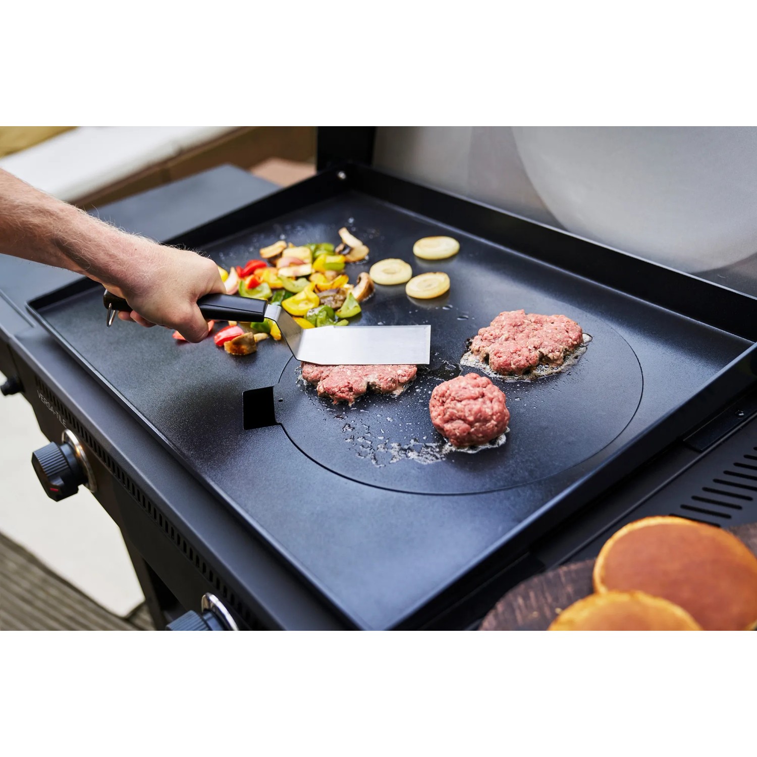 Char-Broil Versa-Tile Gasgrill beim Braten von Burger, Gemüse und Pancakes auf der Grillplatte.