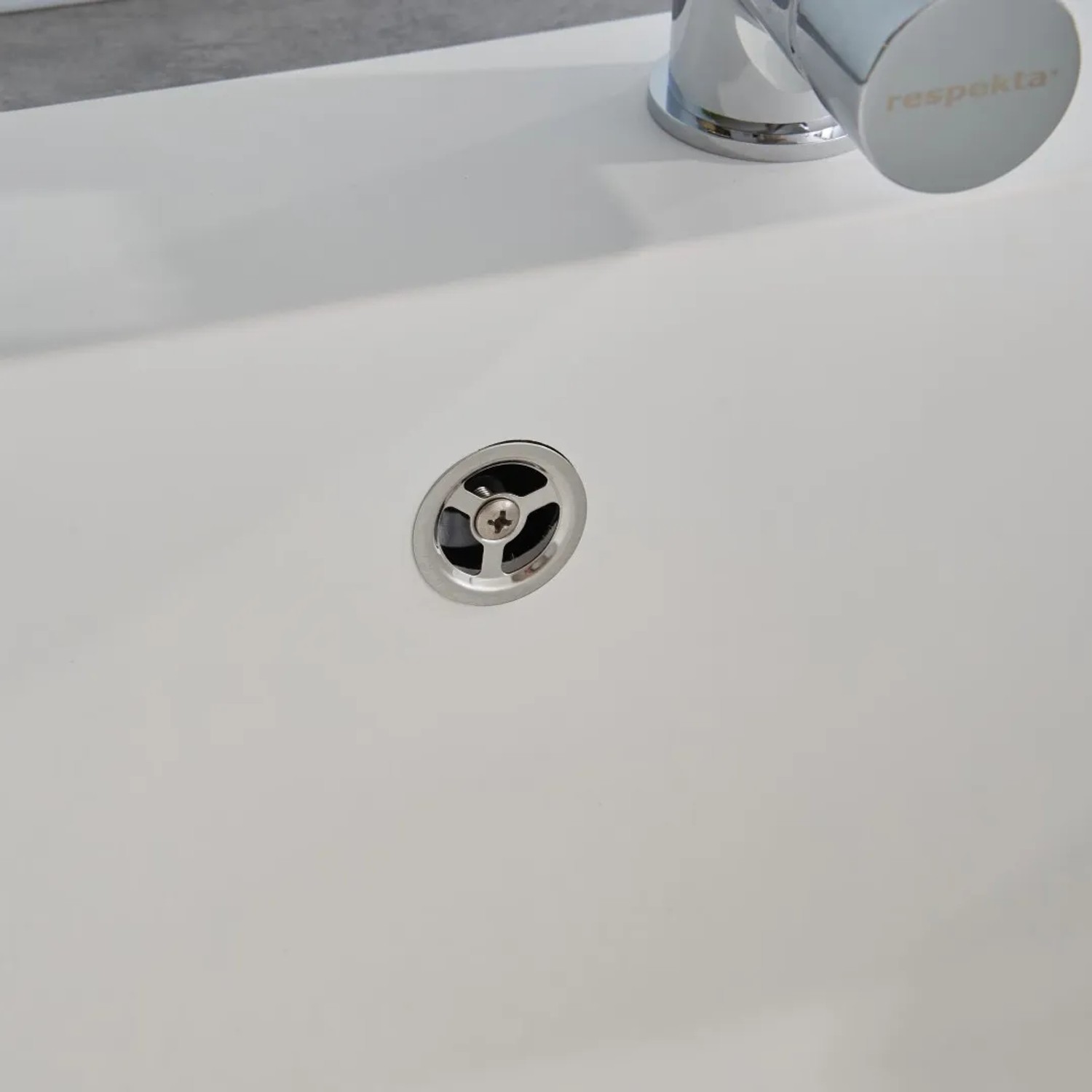 Detailaufnahme: Weiße Respekta Mineralite Einbauspüle Ohio mit Siebkorb.