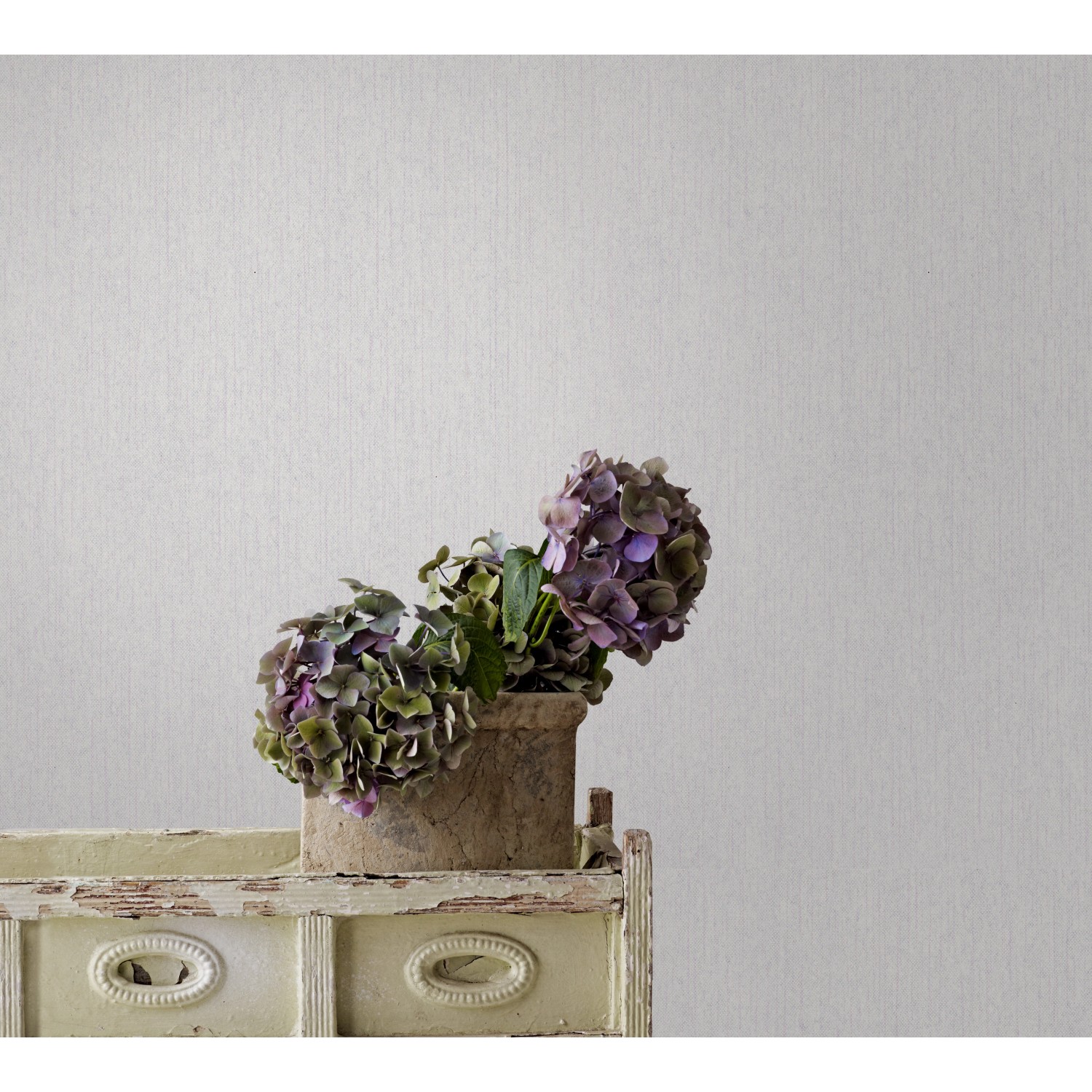 Beige Vliestapete Jackie 5 von Marburg mit feiner Struktur und Hortensien im Topf.
