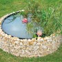 Runder Gabionen-Hochteich (Ø 146 cm) mit Steinen, Wasser, Seerosen und Pflanzen im Garten.