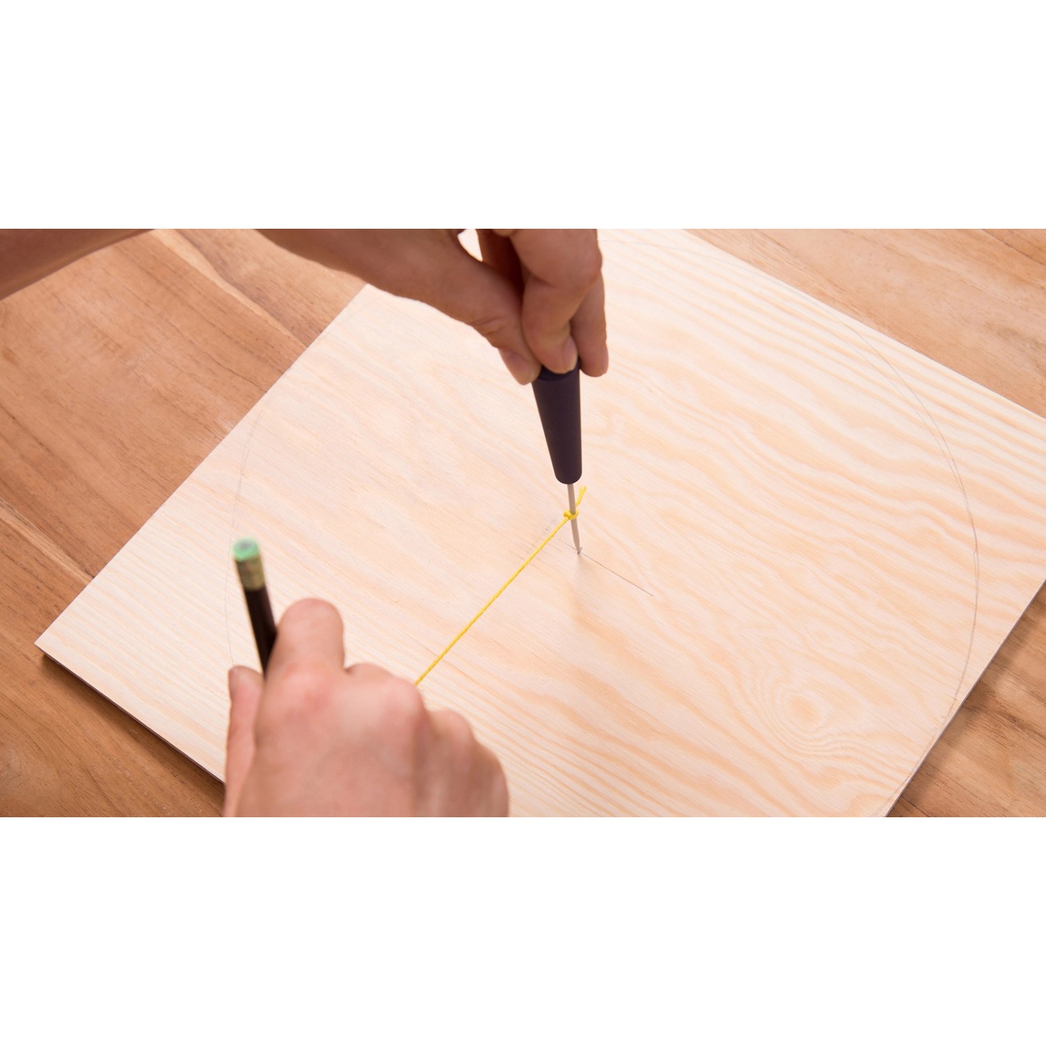 Dremel Holzbearbeitungs-Set in Aktion: Kreis wird mit Werkzeug und Bleistift auf Holz gezeichnet.