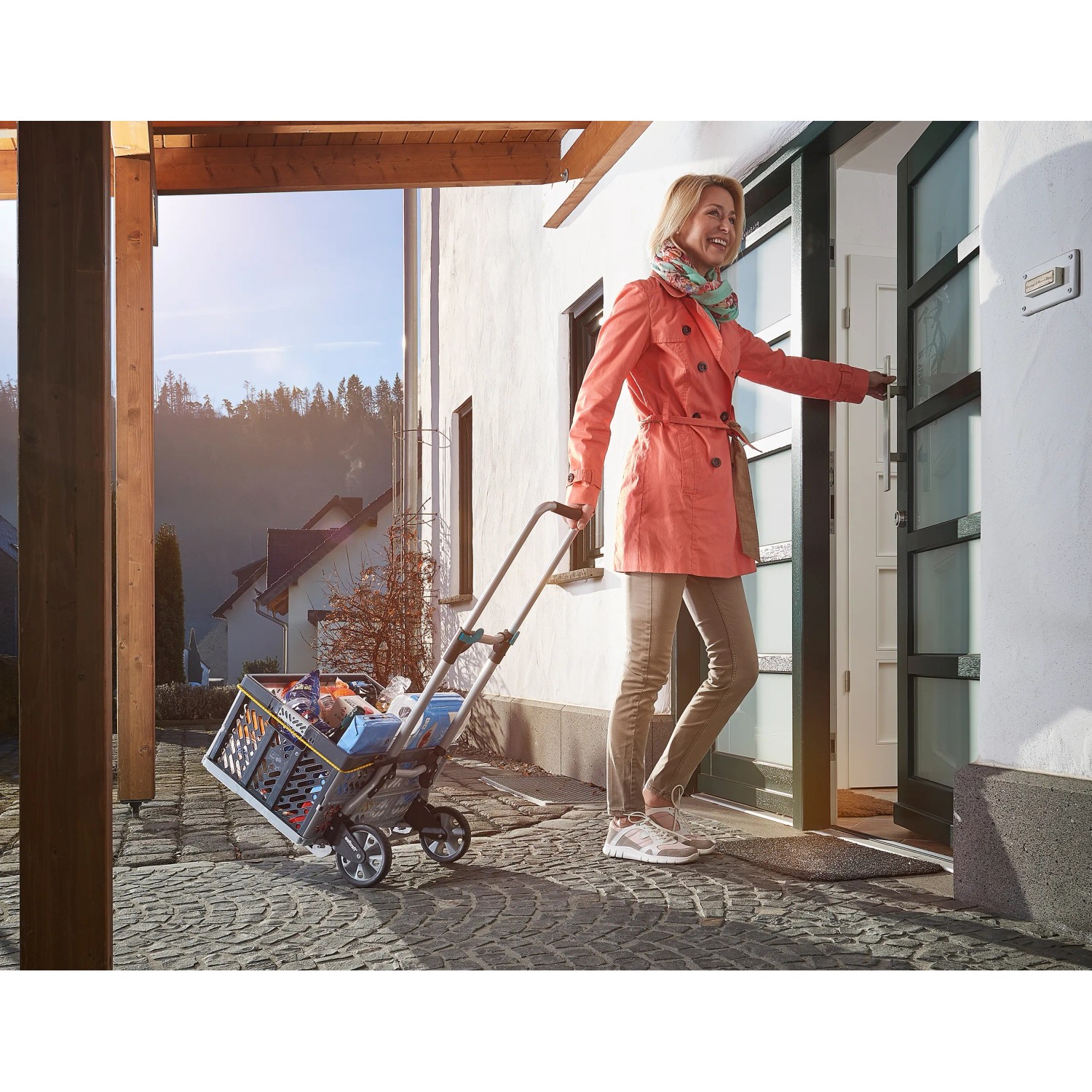 Frau zieht klappbare wolfcraft Sackkarre TS 600 mit Einkäufen zum Haus.