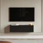 Schwarzes Selsey Veldio TV-Hängeboard 100 cm mit geriffelter Lamellenfront, schwebend unter einem Fernseher.