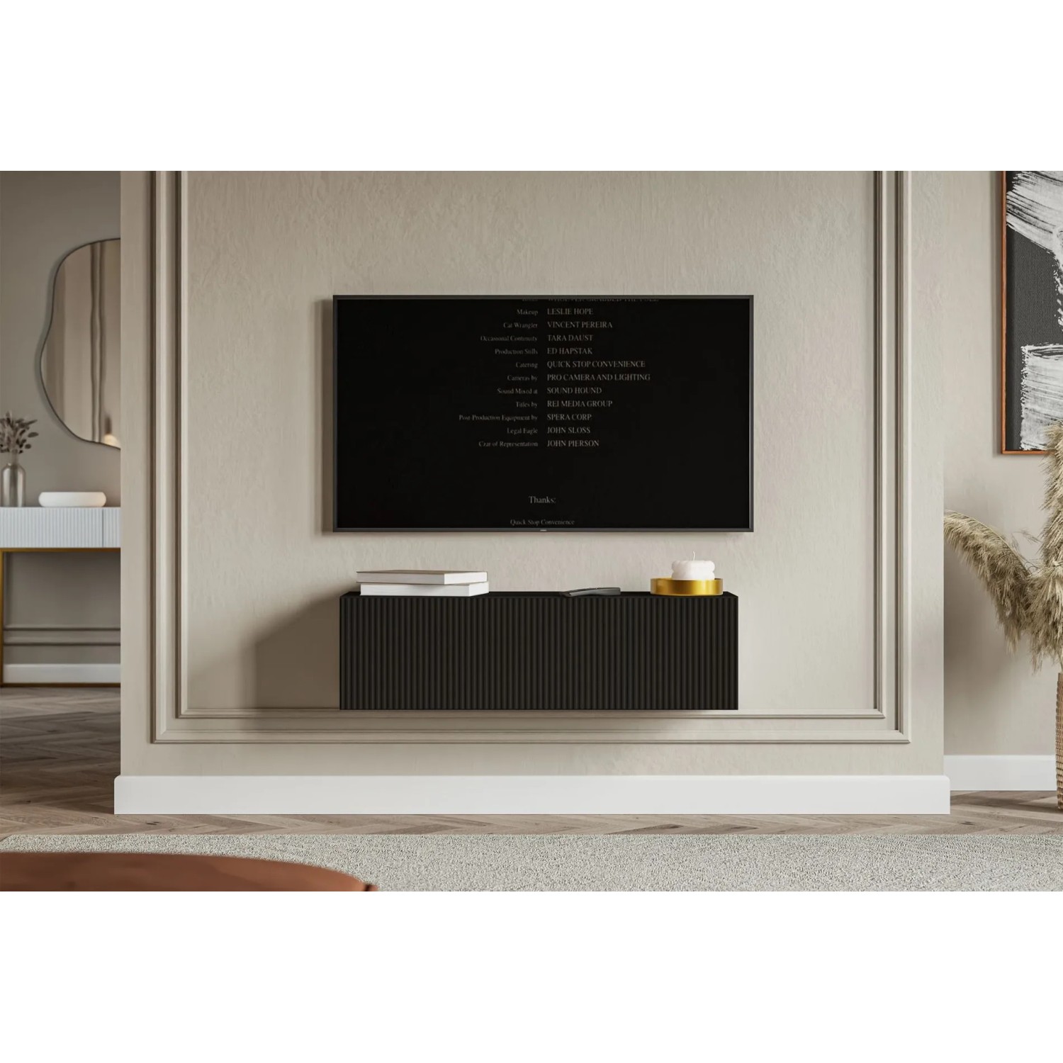 Schwarzes Selsey Veldio TV-Hängeboard 100 cm mit geriffelter Lamellenfront, schwebend unter einem Fernseher.