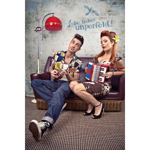 Komar Wandtattoo "Lebe Lieber Unperfekt": Paar mit Ukulele und Akkordeon auf Sofa vor Wand mit Spruch.