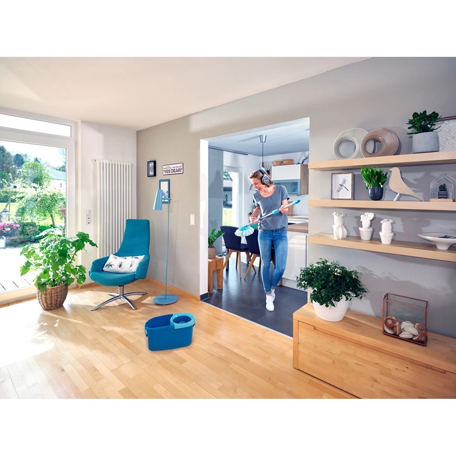 Frau wischt Boden mit Leifheit Clean Twist Disc Mop Ergo Reinigungsset, blauem Eimer und Wischmop.