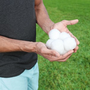 Hände halten Bestway Pool Filterbälle (500g) vor grünem Hintergrund. Filtermedium für Sandfilteranlagen.