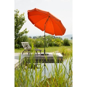 Terracottafarbener Schneider Balkonschirm Aquila Ø 250 cm mit Push-Up Mechanik neben einem Teich.