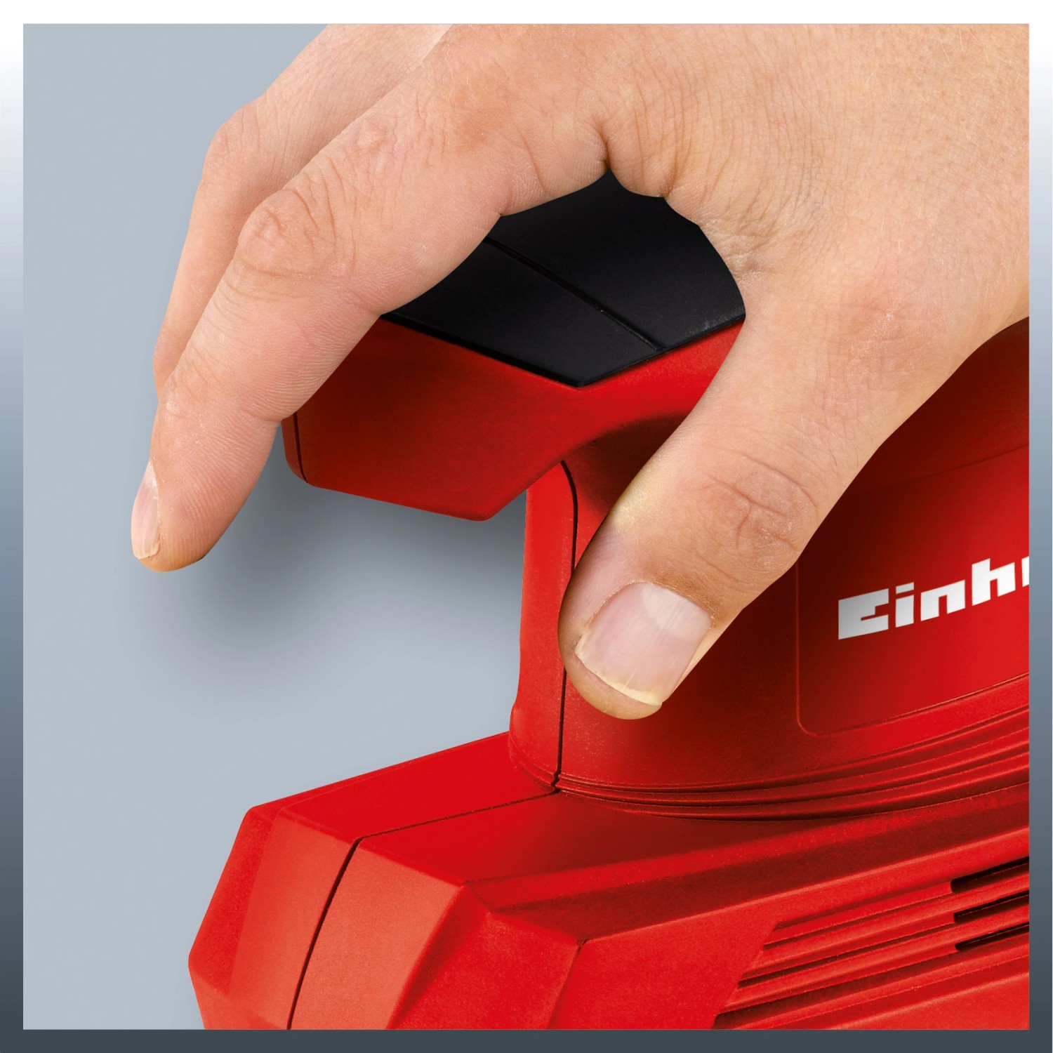 Einhell TC-OS 1520 Schwingschleifer in Benutzung, rote Schleifmaschine mit Hand am Schalter.