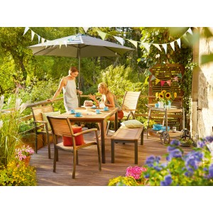 Gartenszene mit Holz Stapelstuhl Bonlee und Gartentisch auf einer Terrasse.