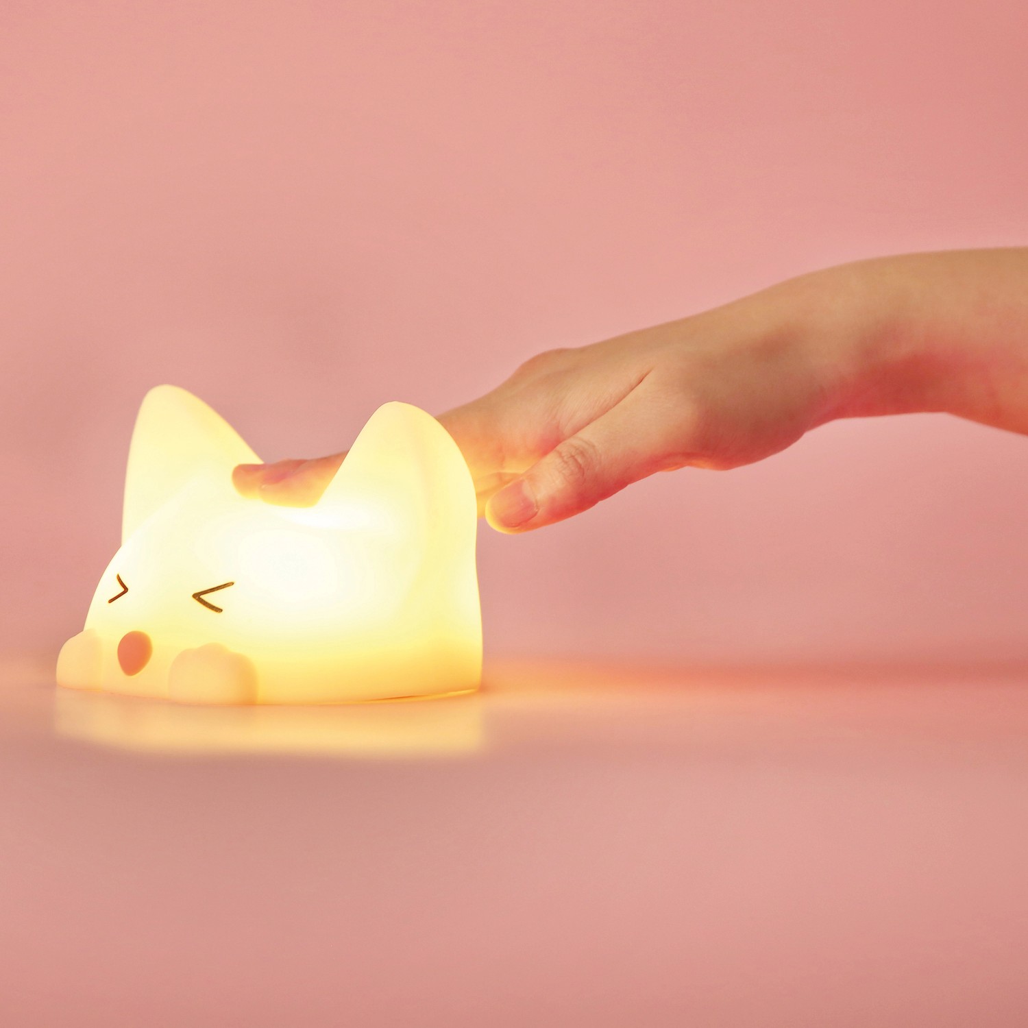Dimmbares LED Kinder-Nachtlicht Catty Cat mit Soundeffekt und Hand auf dem Kopf.