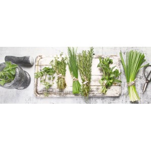 Glasbild Ingredients: Kräuter wie Schnittlauch, Thymian und Minze auf Holzbrett mit Mörser.