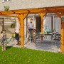 Freistehende Skan Holz Terrassenüberdachung Siena aus Leimholz Eiche hell, mit Familie im Garten.