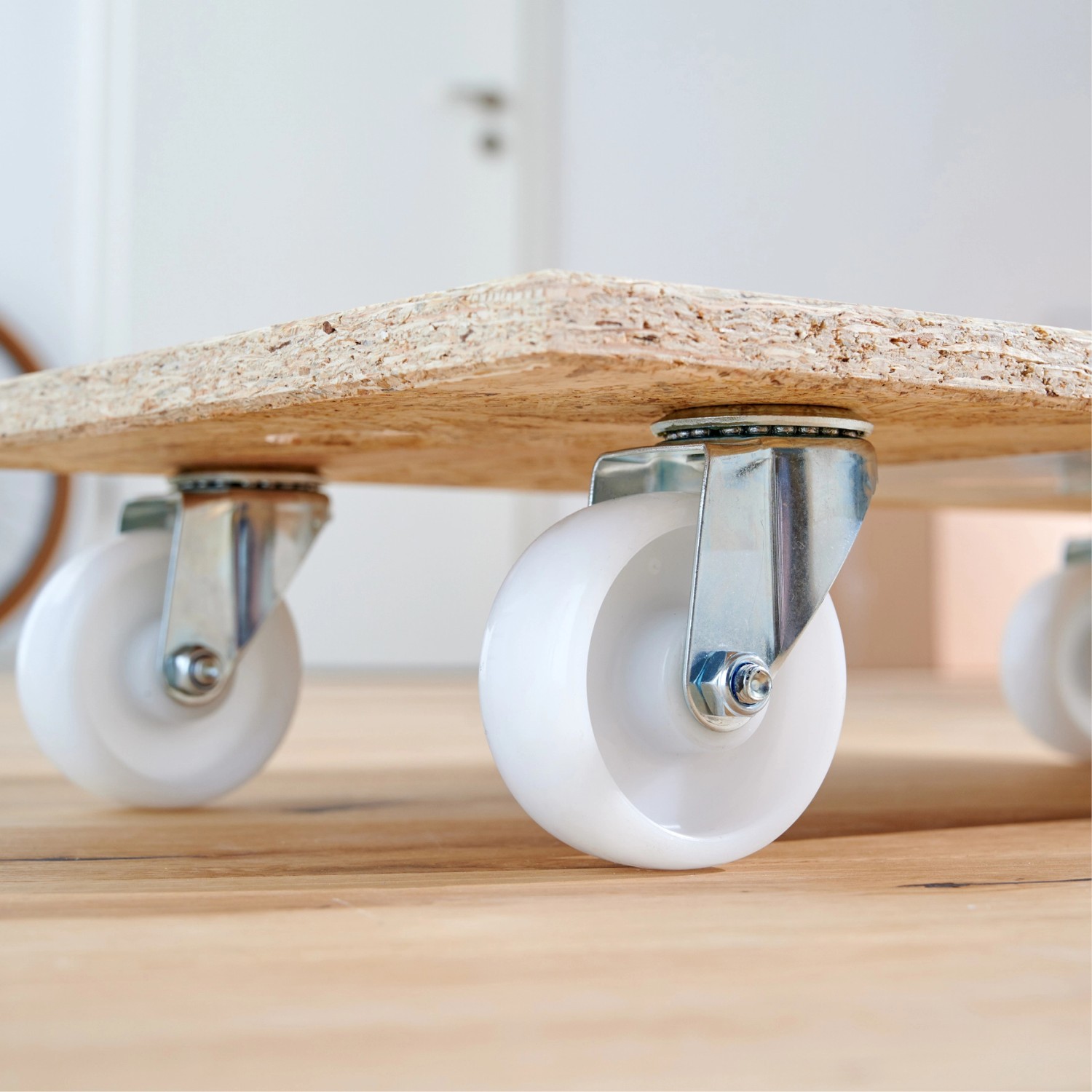 Wagner Transporthilfe mit OSB-Platte und vier weißen Rollen für den einfachen Transport.