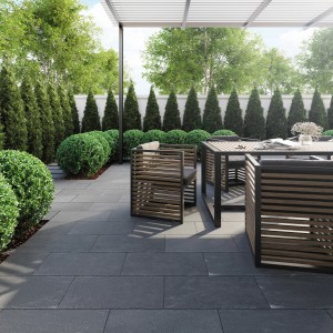 Terrasse mit dunklen Natursteinplatten Lima Black (30x60). Gartenmöbel und grüne Bepflanzung.