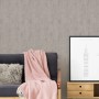 Vliestapete Trendwall 2 Uni Grau Silber Glänzend an Wand hinter Couch mit Decke und Bild.