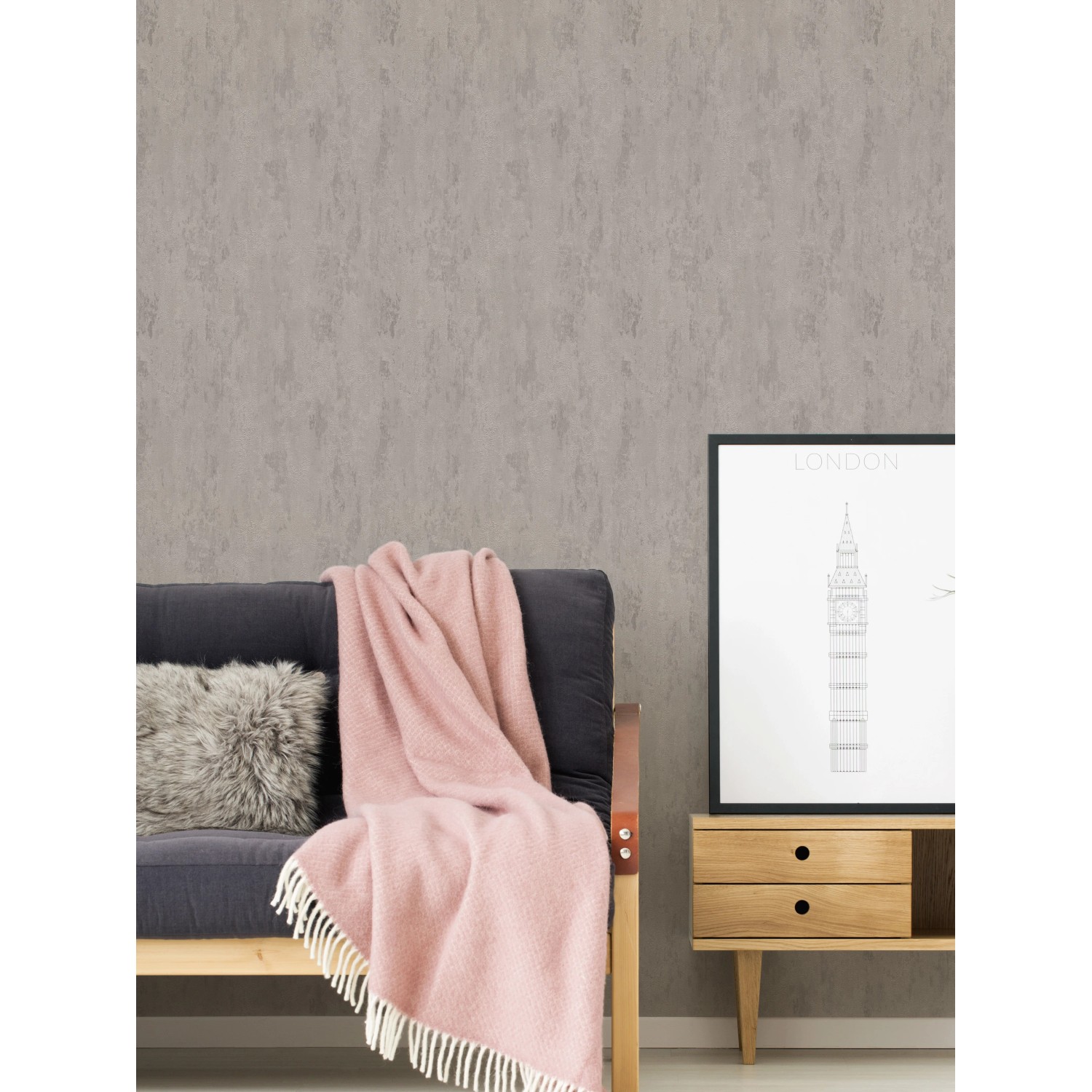Vliestapete Trendwall 2 Uni Grau Silber Glänzend an Wand hinter Couch mit Decke und Bild.