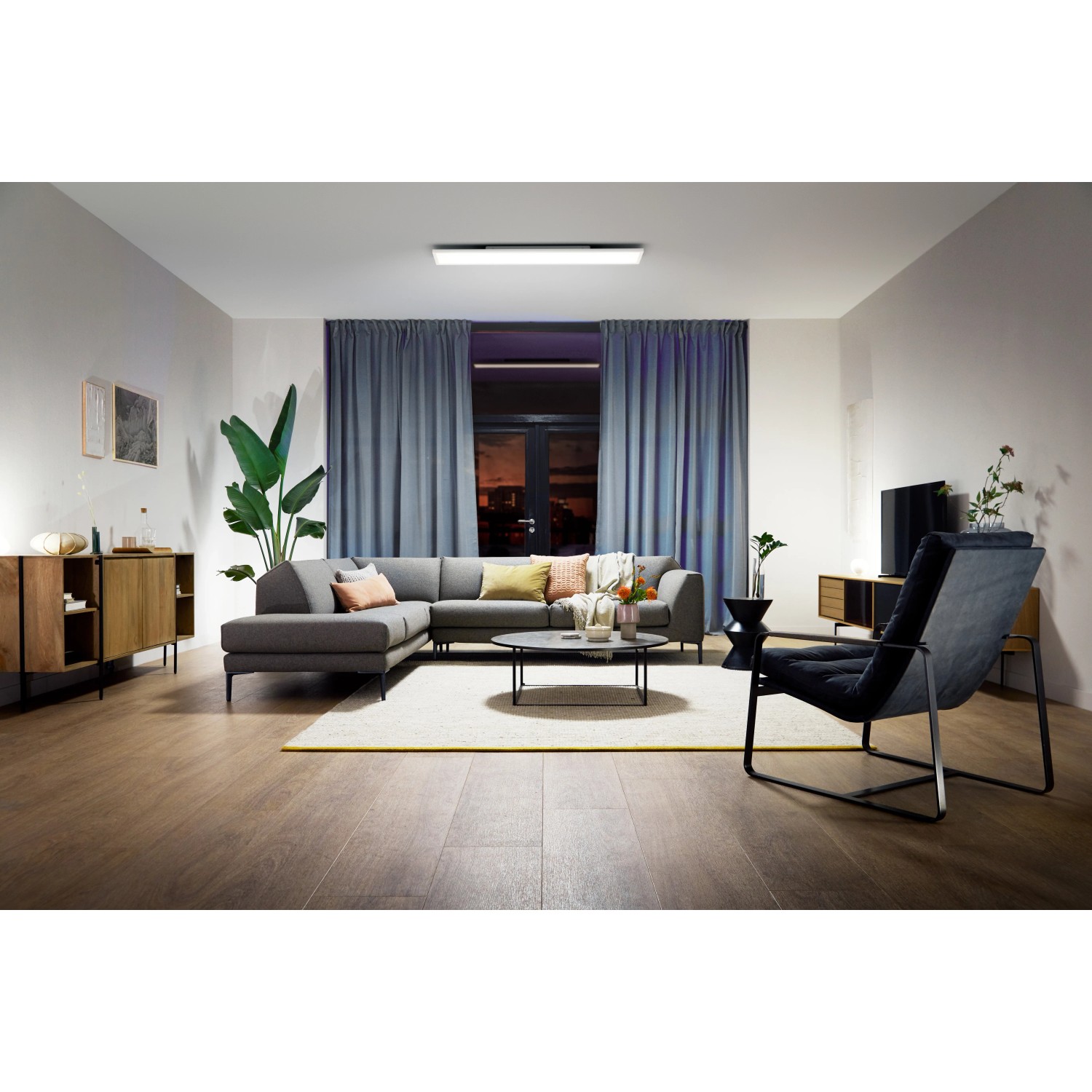 Wohnzimmer mit Philips Hue Aurelle LED-Panel (4,6x120x30 cm) in Weiß, montiert an der Decke.
