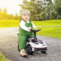 Lächelndes Kleinkind in grünem Overall auf weiß-schwarzem AIYAPLAY Rutschauto im Park.