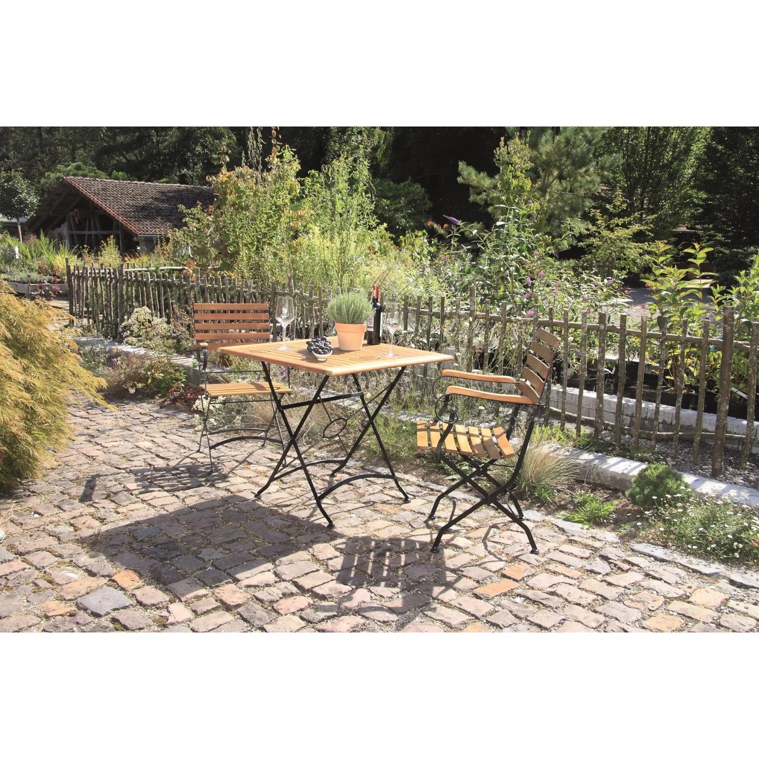 Acamp Klappsessel Lindau Set Teak-Schwarz. Klappbare Gartenstühle aus Akazienholz mit schwarzem Eisenrahmen und Tisch auf Terrasse.