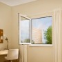 Geöffnetes Fenster mit anthrazitfarbenem tesa® Insect Stop Fliegengitter Premium.