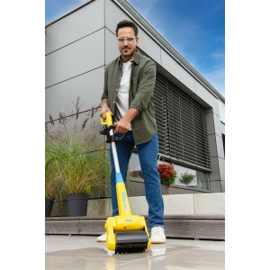 Mann nutzt Gloria MultiBrush Akku-Bürste zur Terrassenreinigung. Gartenhandgerät mit Akku und verschiedenen Bürsten.