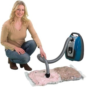 Frau nutzt Wenko Vakuum Beutel Set mit Staubsauger für textile Aufbewahrung.