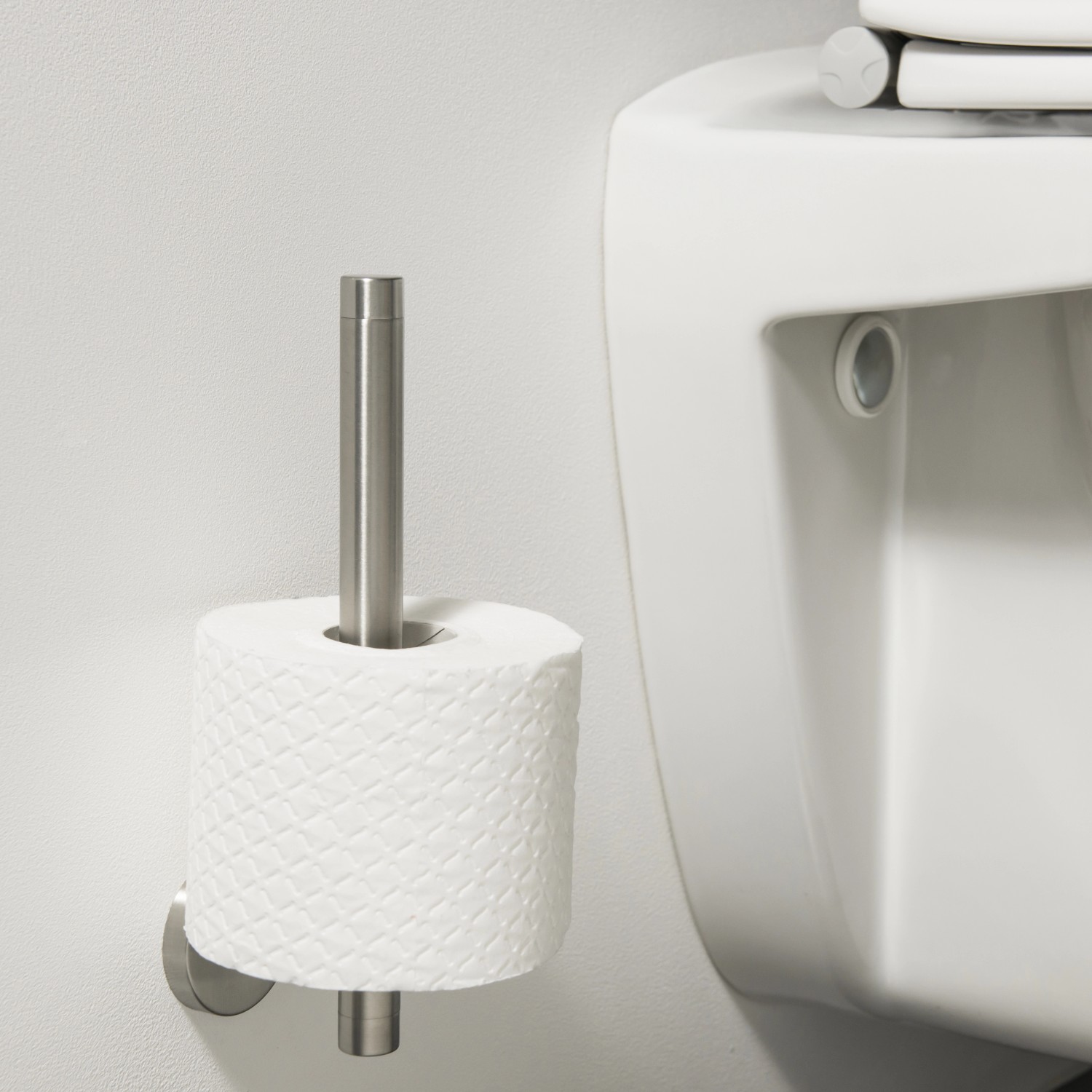 Tiger Boston Reserverollenhalter aus gebürstetem Edelstahl mit Toilettenpapierrolle.