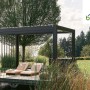 Moderne Biohort Pergola 5,5 m x 3 m in Quarz-Silber mit Lamellen und zwei Liegen auf einer Holzterrasse.